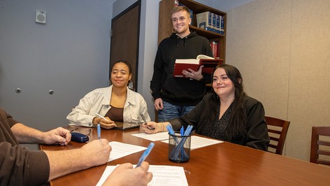 Three students listen to a clinic client.