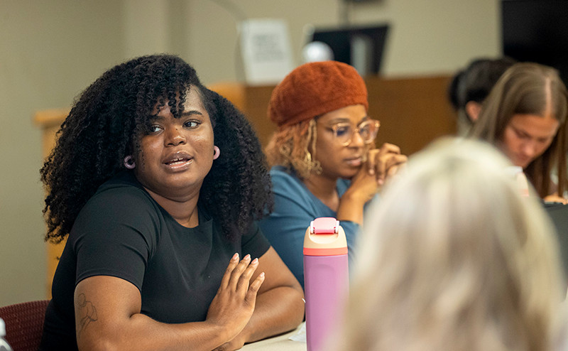 SIU students sitting at a desk engaging in conversation